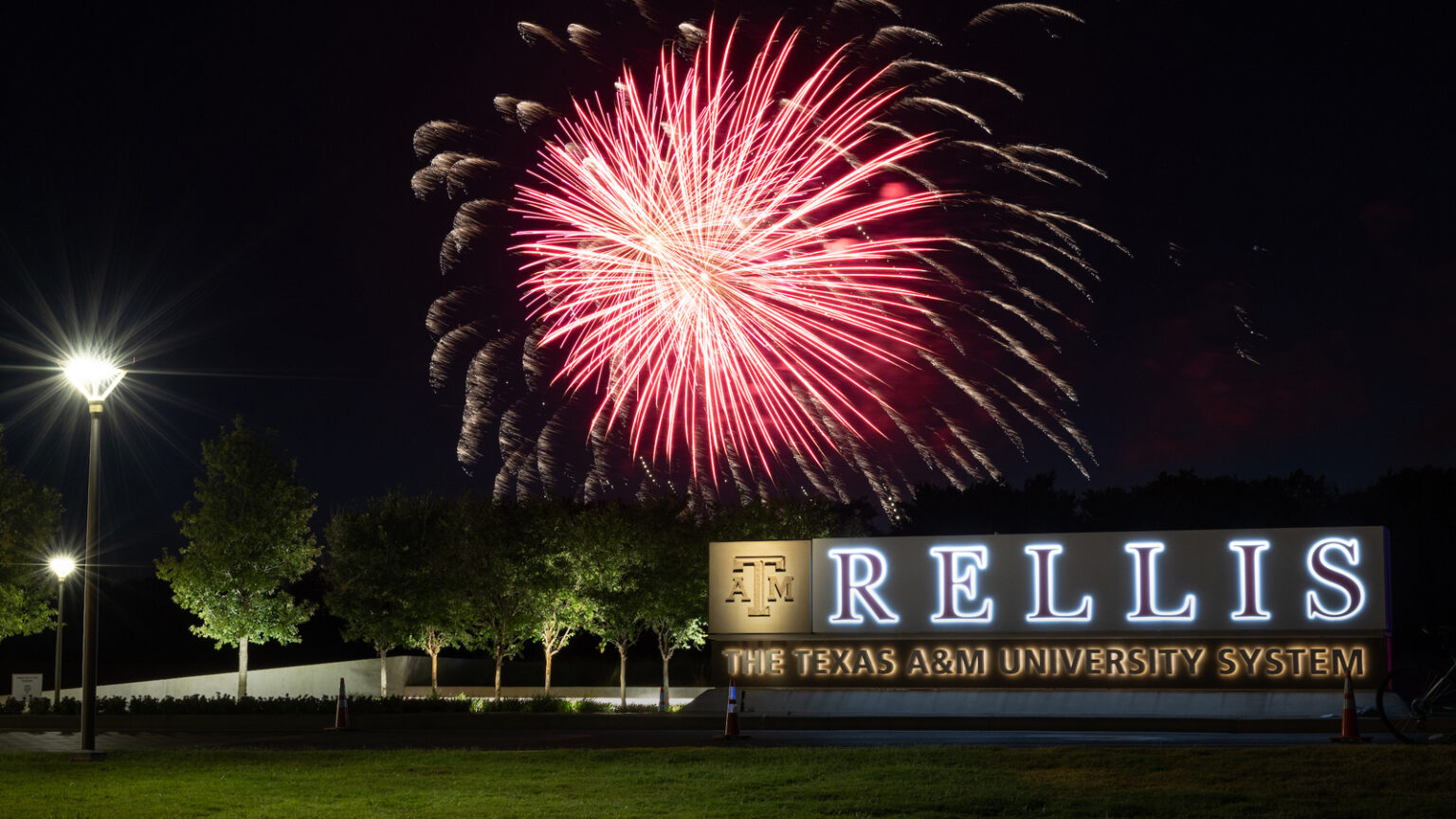 A photo of red fireworks over the sign at Texas A&M University-Rellis Campus.