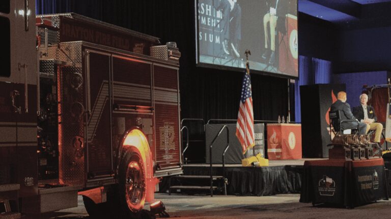 A photo featuring TEEX spokesmen next to a firetruck.