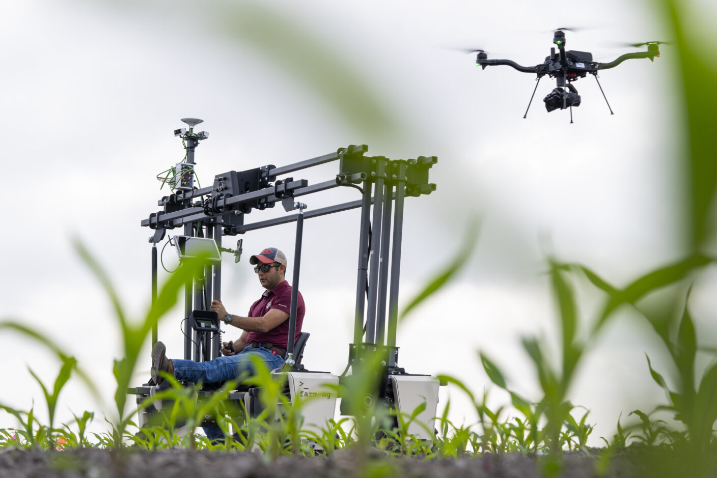Oscar Fernandez demonstrating machinery and a drone on a corn plot