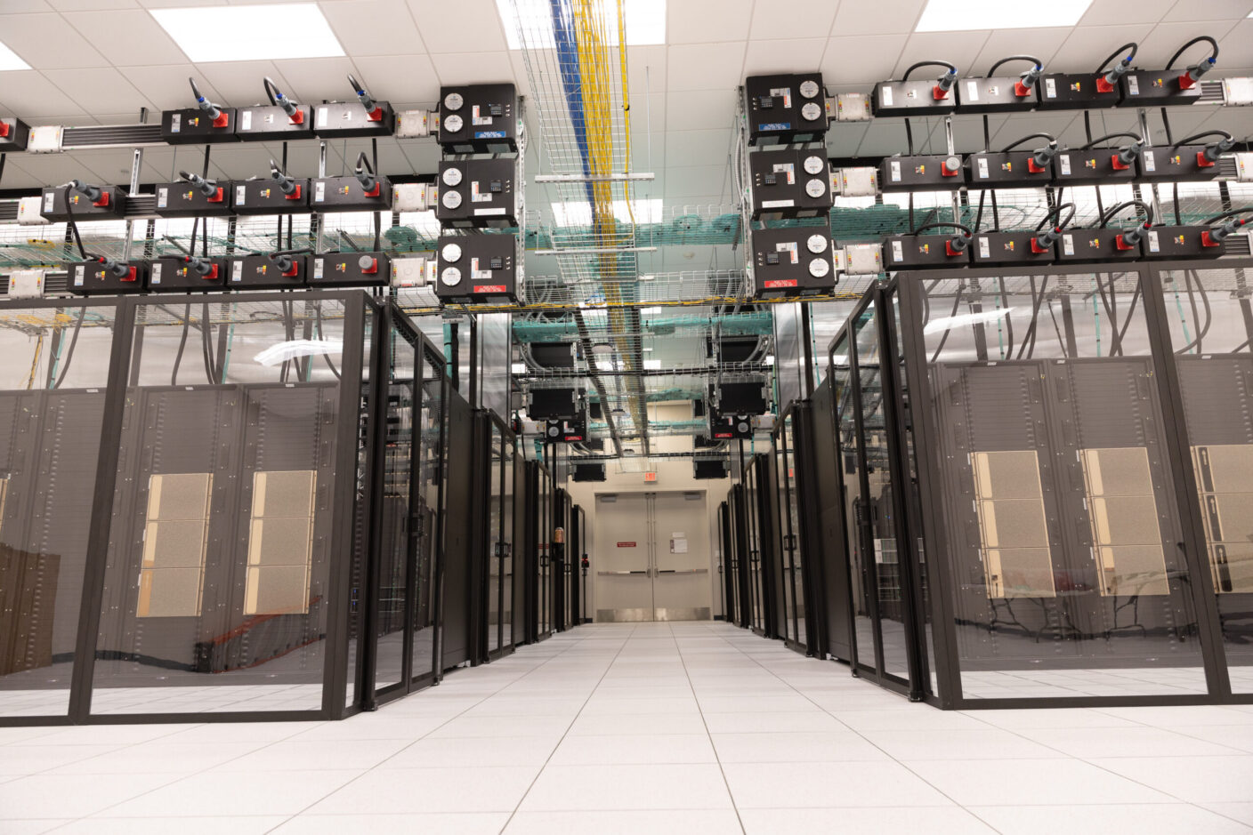 A modern data center with rows of server racks, overhead cable management, and a clean, organized layout.