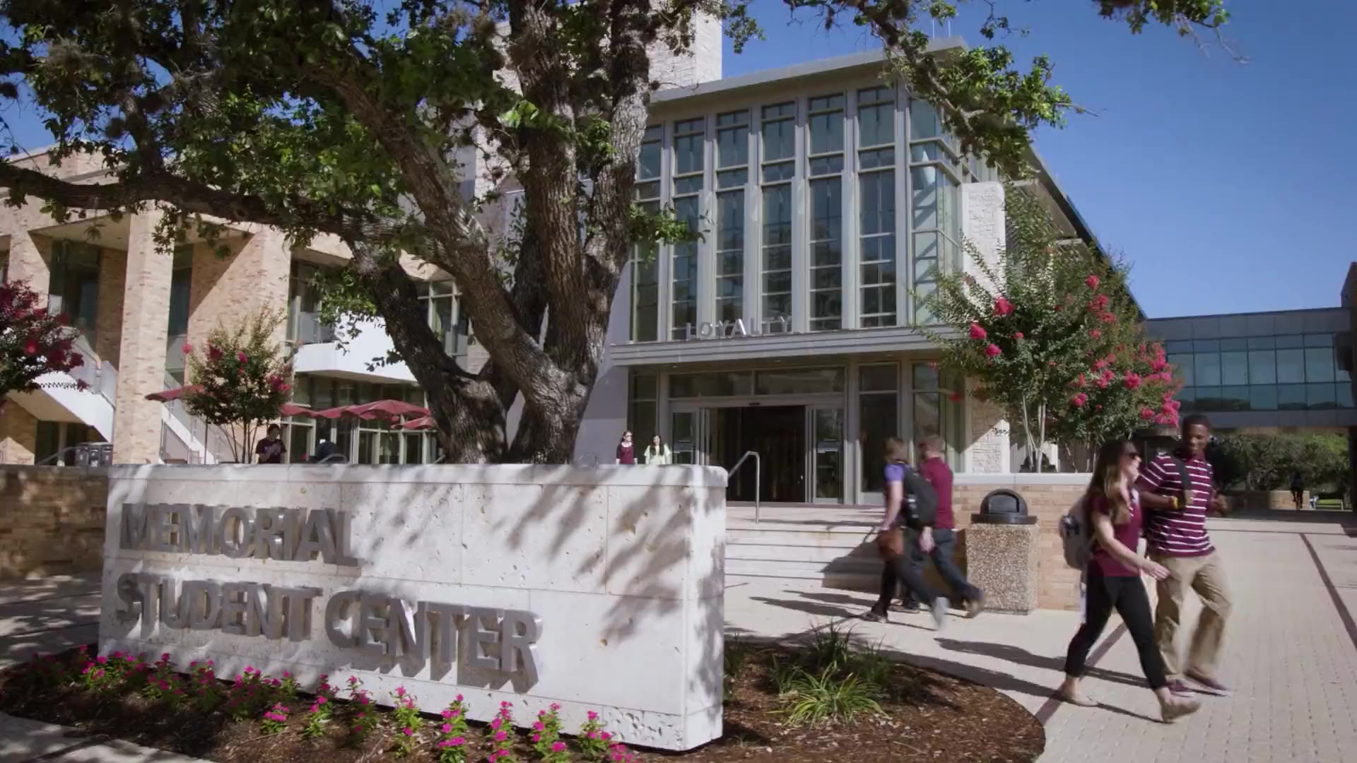 Entrance of the MSC with a sign reading, "Memorial Student Center" and students walking in the background.